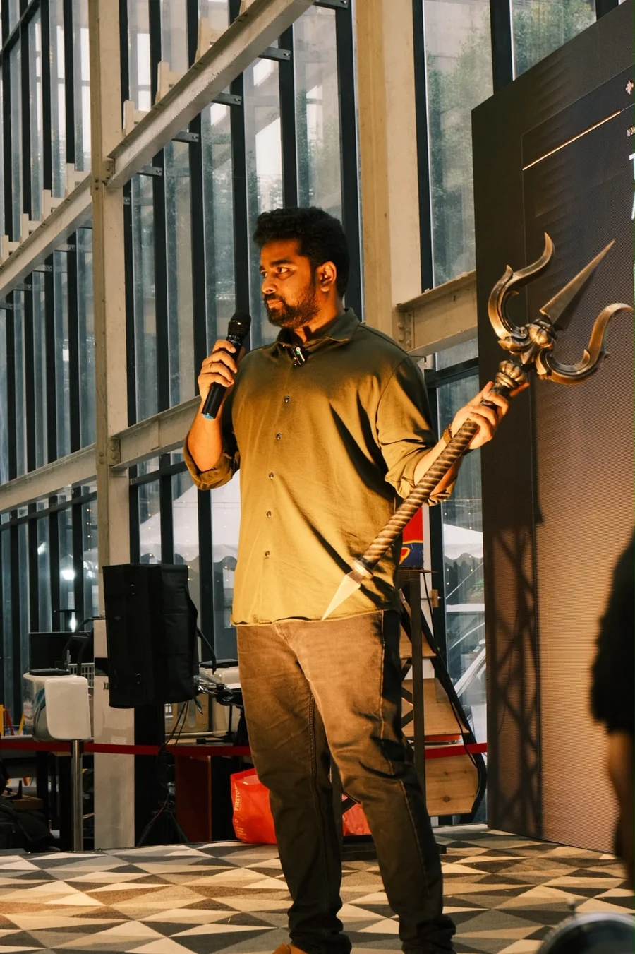 Trinity XR CEO speaking while holding a Trishul at the Hyderabad Film Festival